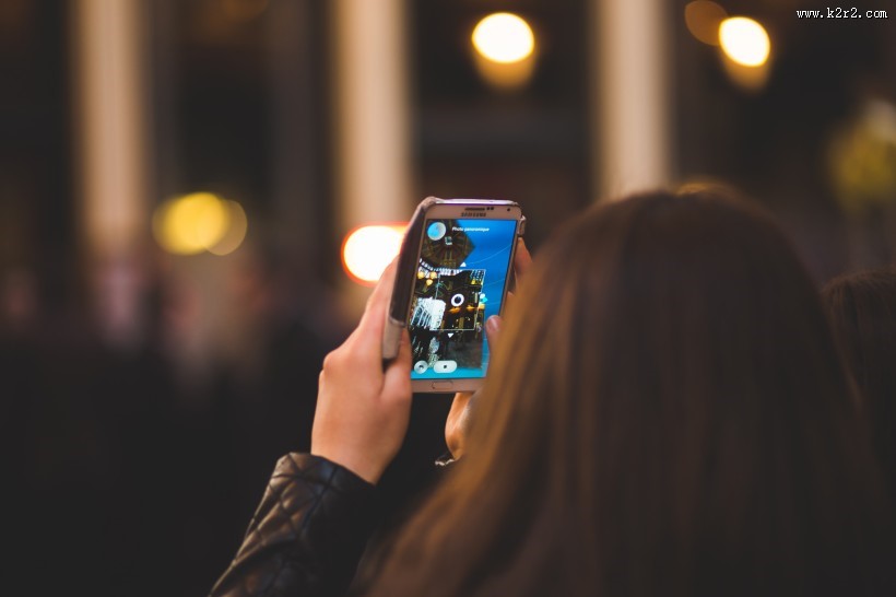 正在用手机拍摄的人物图片