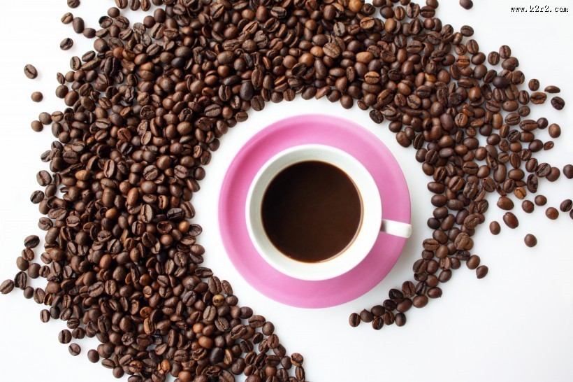 咖啡豆散落在装有咖啡的杯子旁图片大全