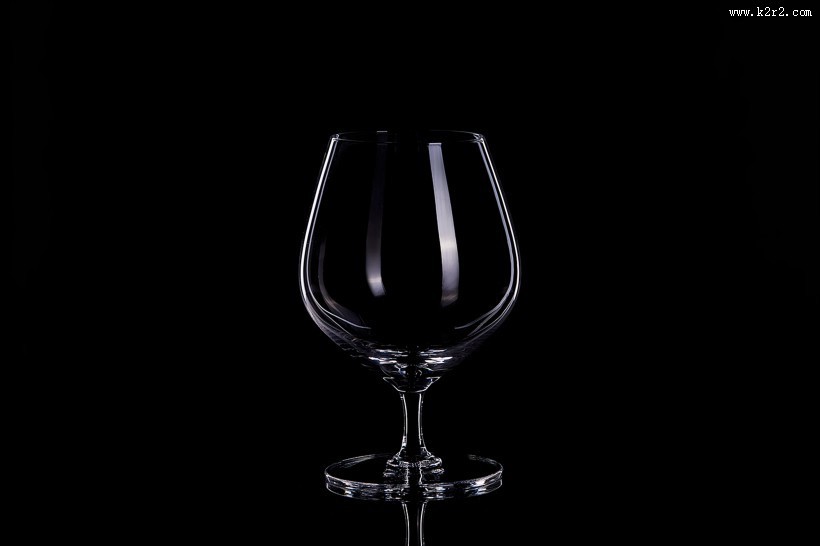 黑色背景透明红酒杯图片