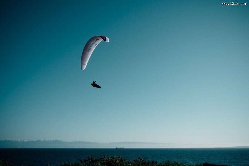 在天空悠闲飞行的滑翔伞图片