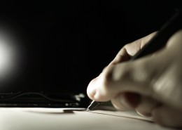 拿着笔书写的图片