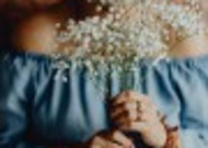 手拿鲜花和马克杯的中年妇女图片