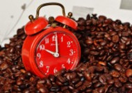 红色闹钟和咖啡豆放在一起图片