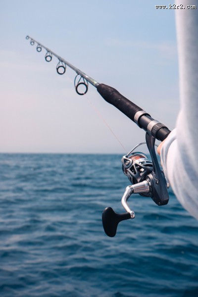 拿着鱼竿钓鱼的人图片