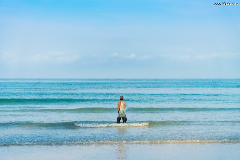 站在海边拍照的人图片