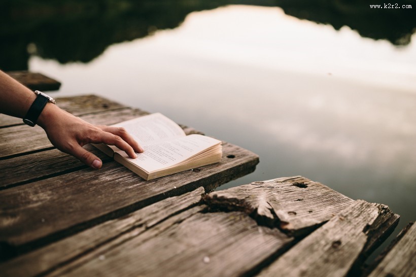 女孩在湖边阅读的图片