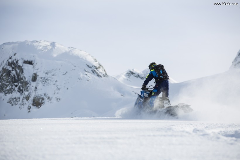 在雪山里开着雪地车的人图片