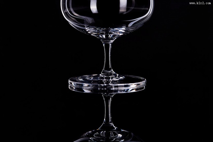 黑色背景透明红酒杯图片