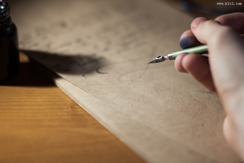 拿着笔书写的图片