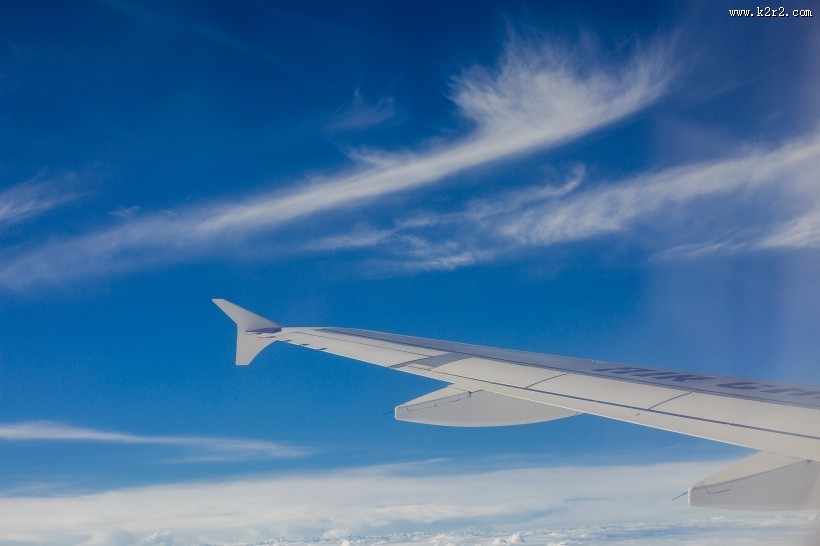 高空云层上的飞机机翼图片